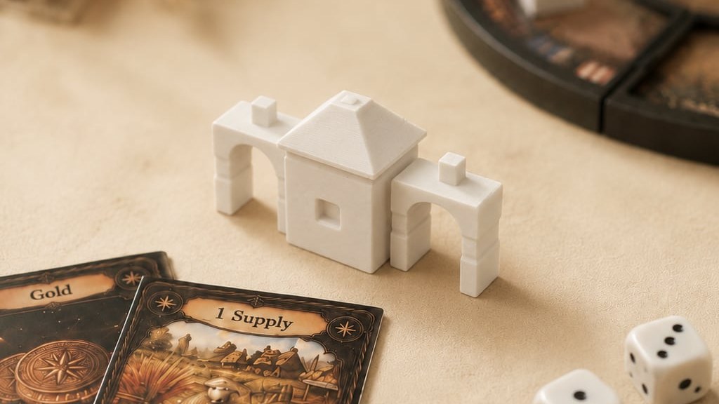 A close-up of assembled Karnwold pieces — two arches flanking a roofed hall — beside a Gold card, a 1 Supply card and two dice.